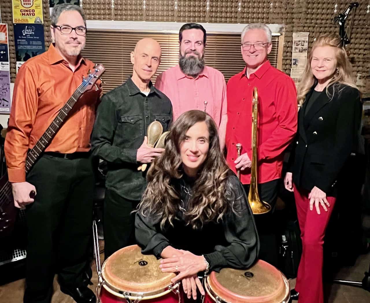 Group of musicians performing with instruments in a recording studio.