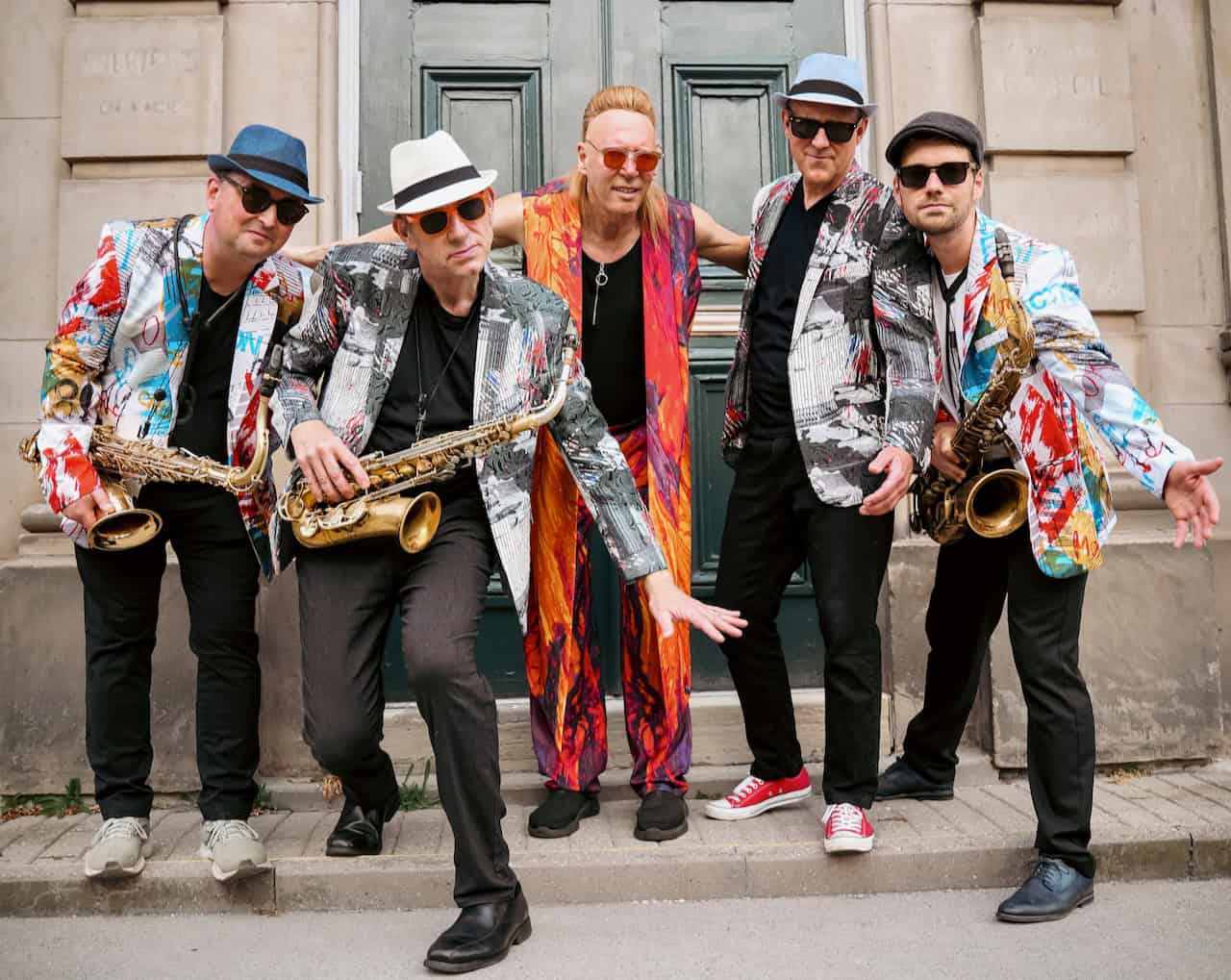 Live jazz band with saxophonist and musicians in colorful jackets.